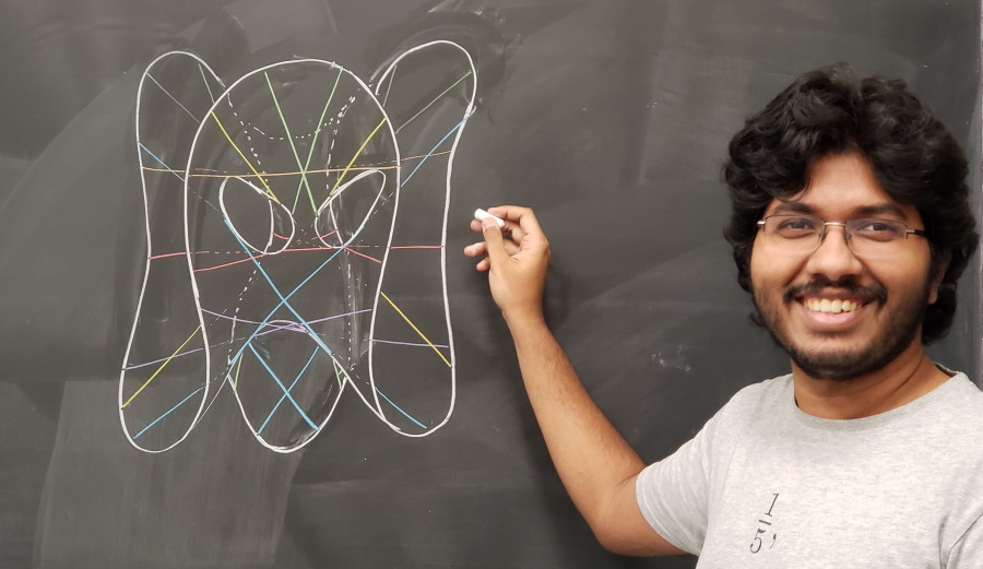 staged photo of me with a cubic surface and 27 lines on a blackboard